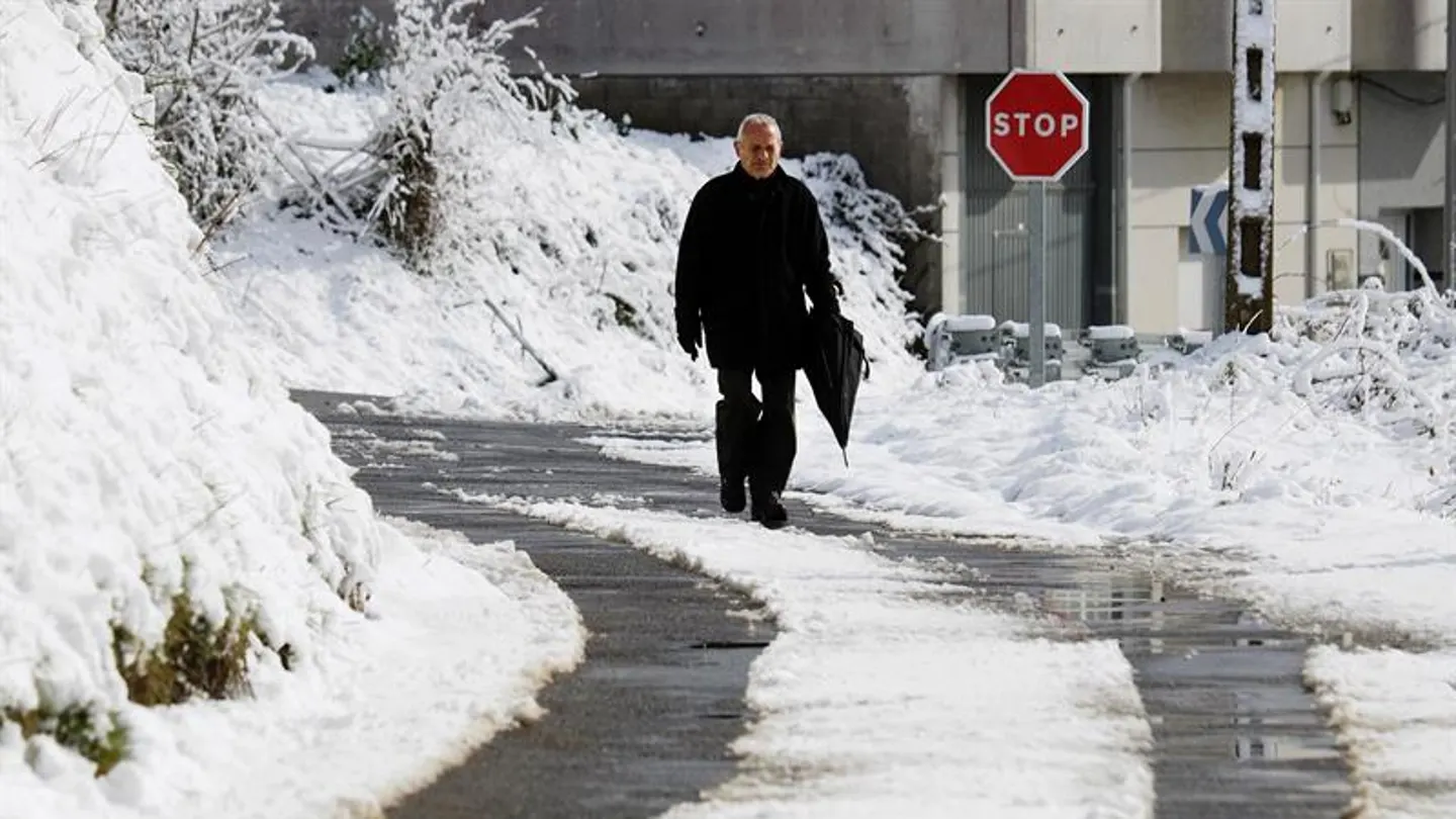 Un hombre caminando por la nieve Un hombre caminando por la nieve