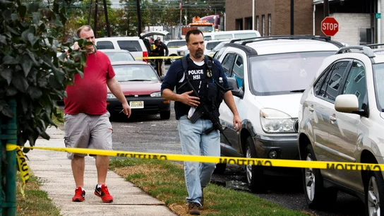 Oficiales de policía trabajan en la escena de un tiroteo Oficiales de policía trabajan en la escena de un tiroteo