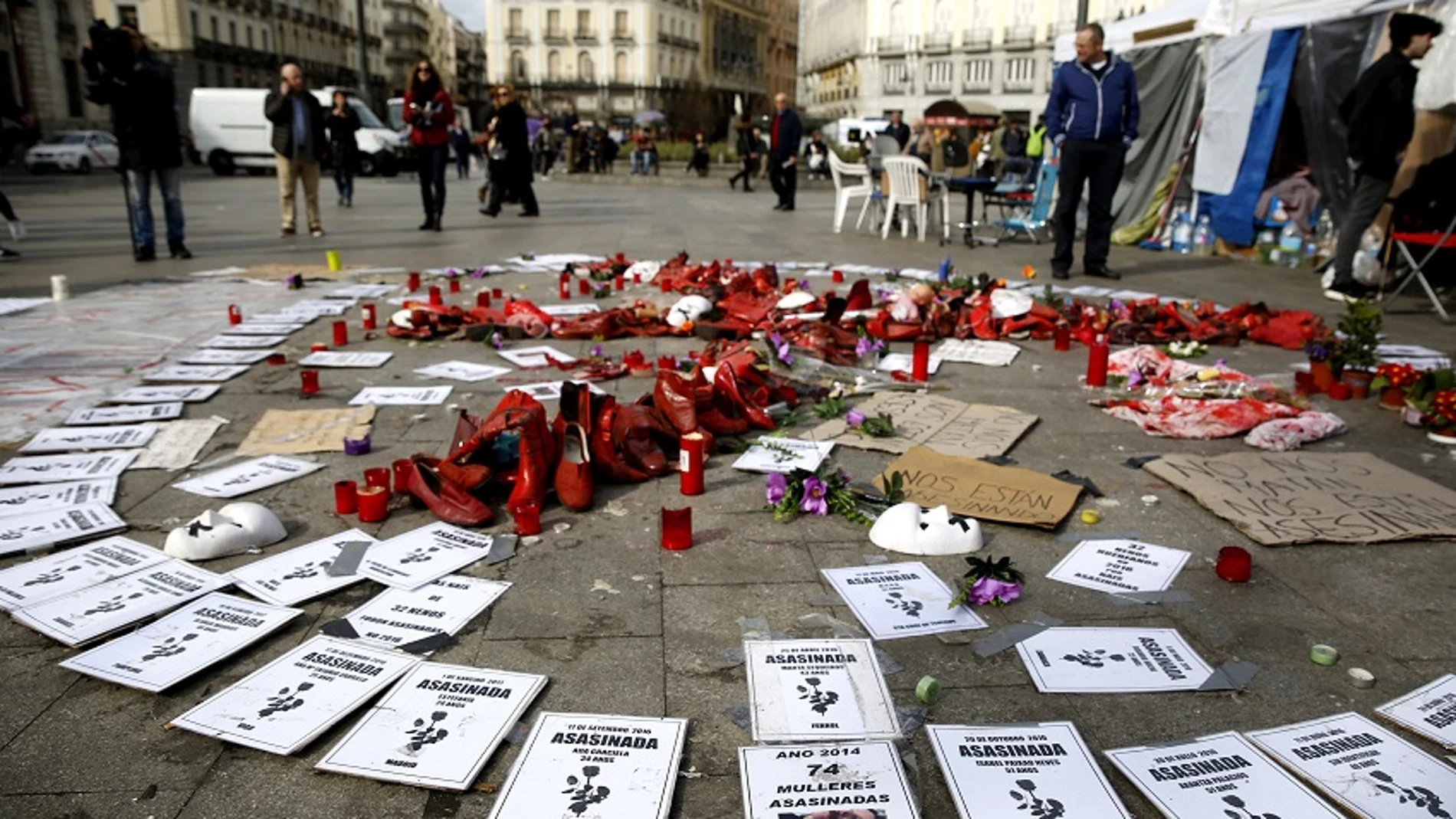 Detalle de flores,zapatos y carteles en una acampada contra la violencia machista en la Puerta del Sol de Madrid. 