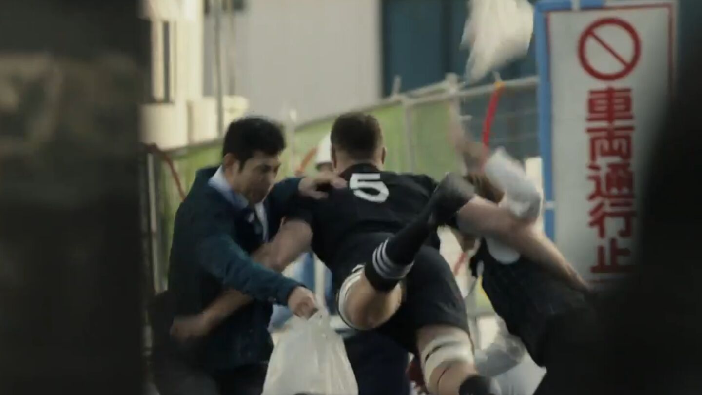 Un miembro de los All Blacks, placando a dos japoneses