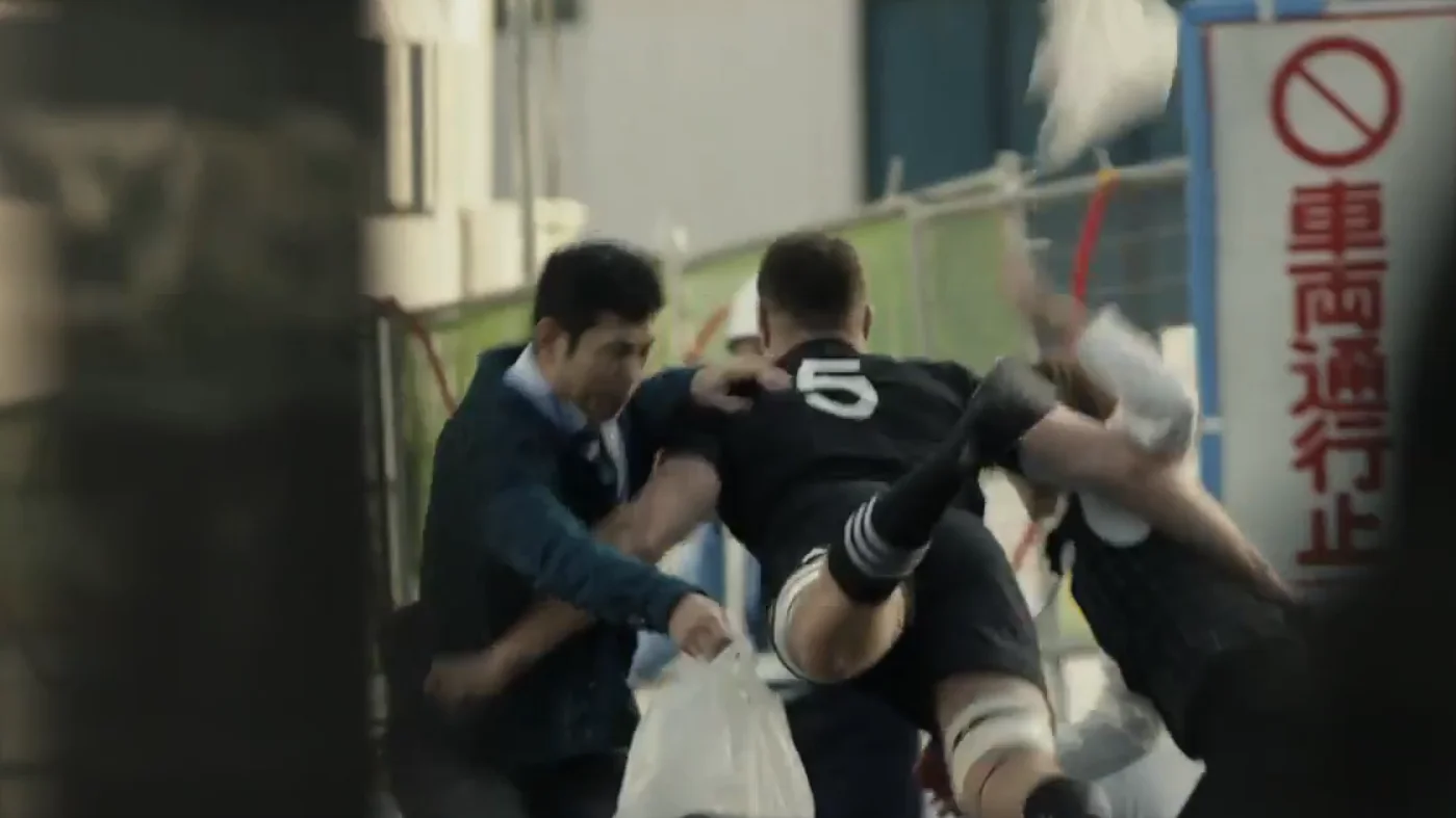 Un miembro de los All Blacks, placando a dos japoneses