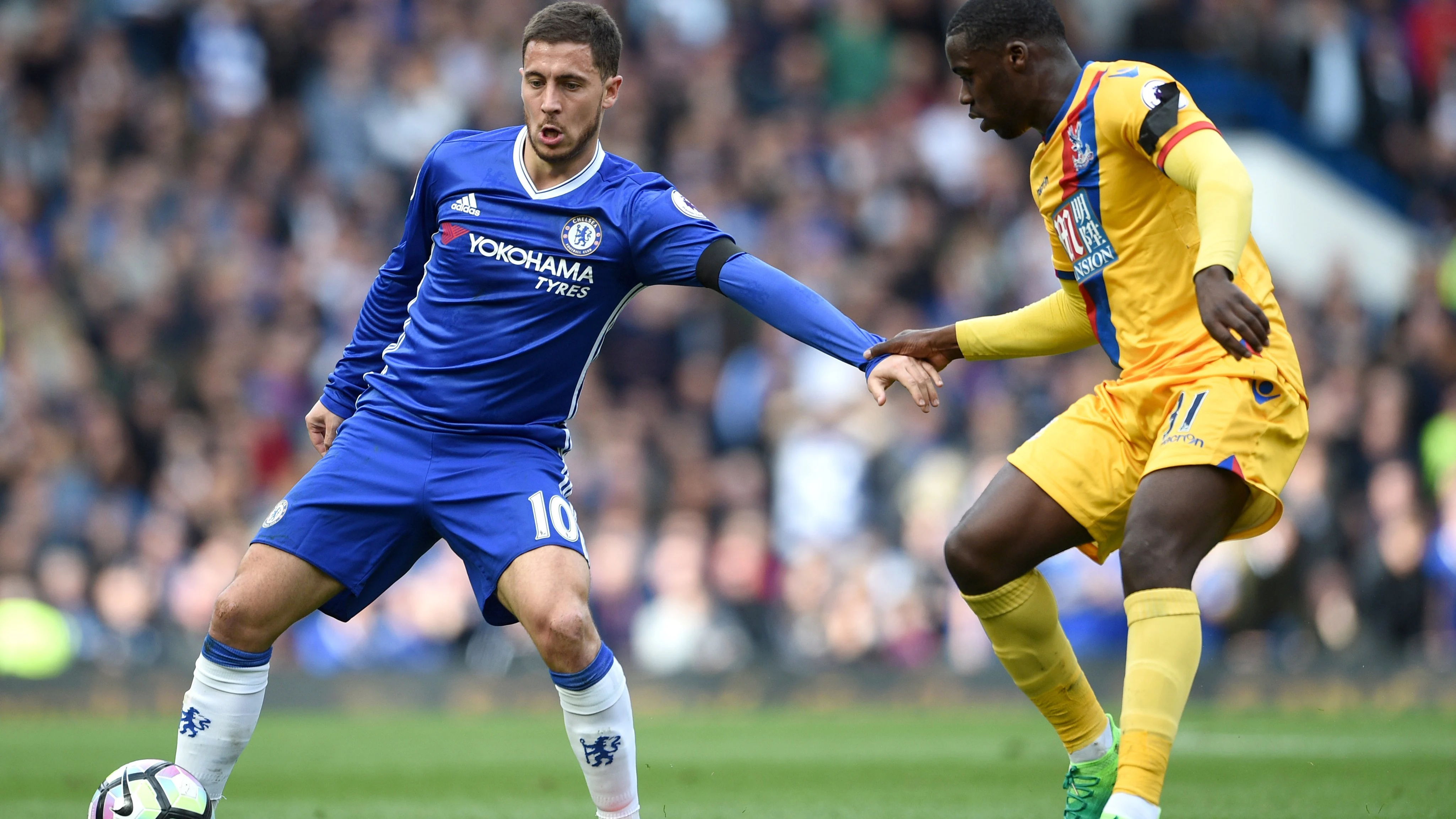 Hazard defendiendo un balón frente a Zaha