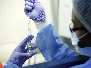 Una mujer examinando pruebas en un laboratorio Una mujer examinando pruebas en un laboratorio