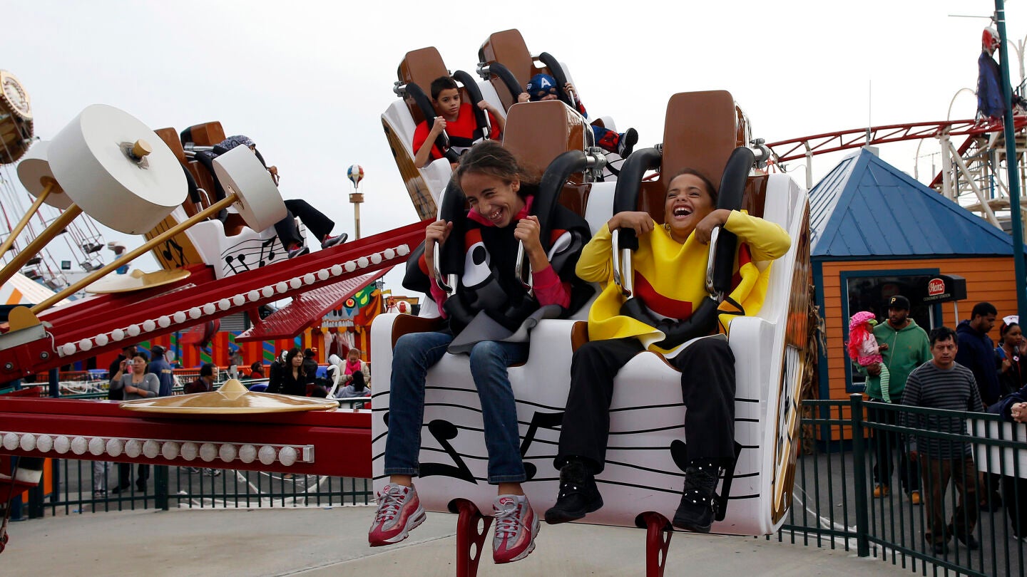 Dos ni&ntilde;os montados en una atracci&oacute;n de feria 