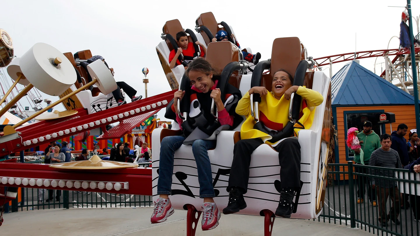 Dos niños montados en una atracción de feria Dos niños montados en una atracción de feria