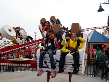 Dos niños montados en una atracción de feria Dos niños montados en una atracción de feria