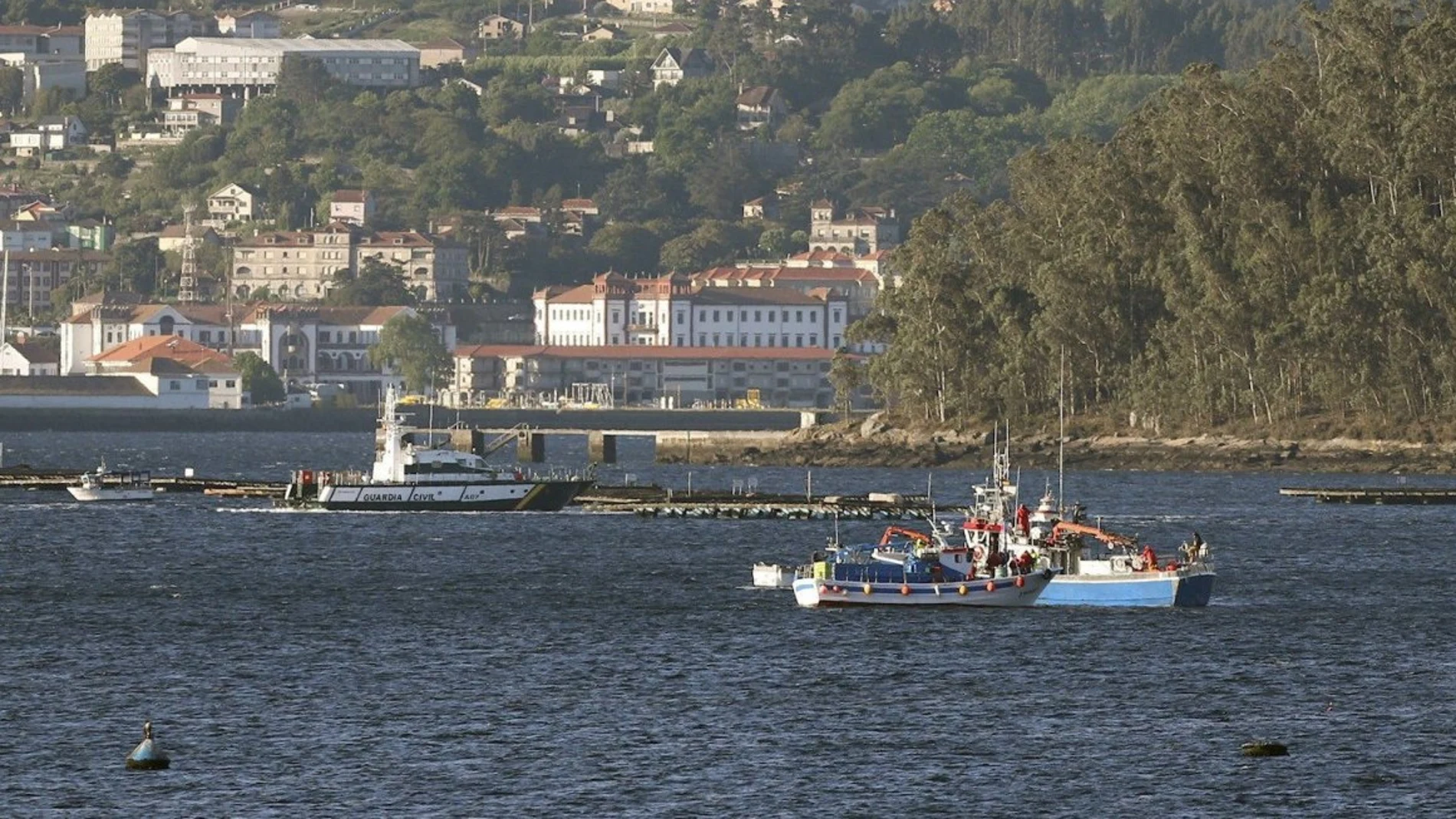 Imagen de una embarcación de la Guardia Civil junto a varias bateas