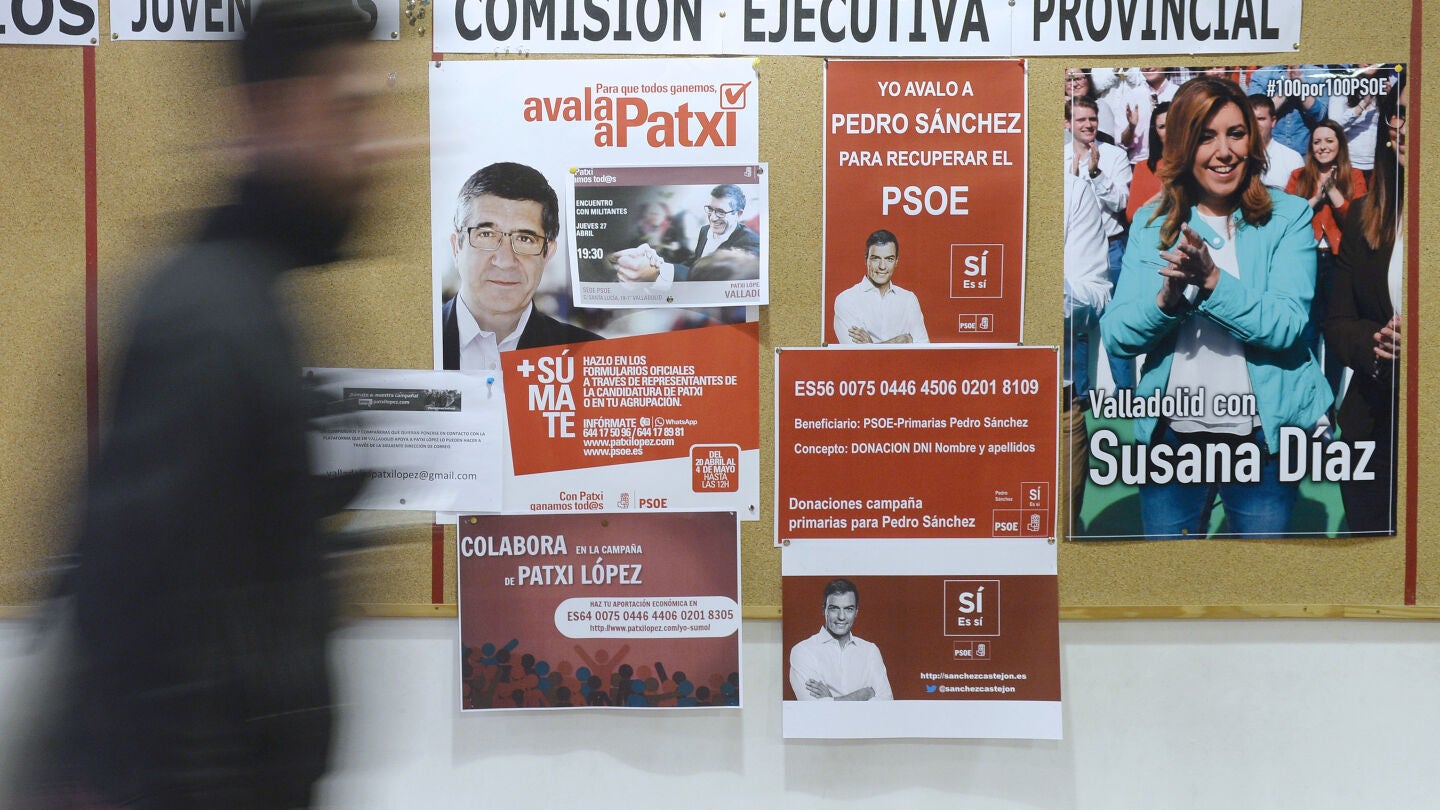 Un hombre pasa por delante de los carteles de apoyo a los tres candidatos a la Secretar&iacute;a General del PSOE
