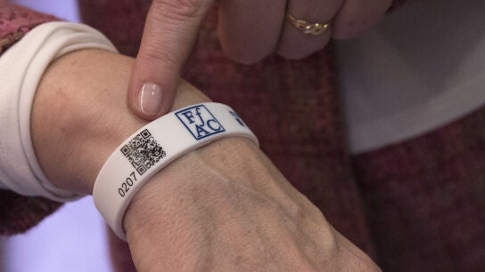 La presidenta de la Federaci&oacute; d'Associacions de familiars d'Alzheimer de Catalunya (FAFAC), Immaculada Fern&aacute;ndez, posa con la pulsera de silicona con un c&oacute;digo QR