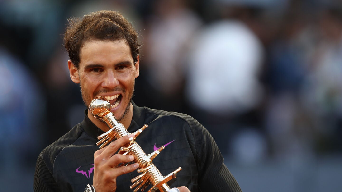 Rafa Nadal muerde su trofeo de campe&oacute;n del Mutua Madrid Open