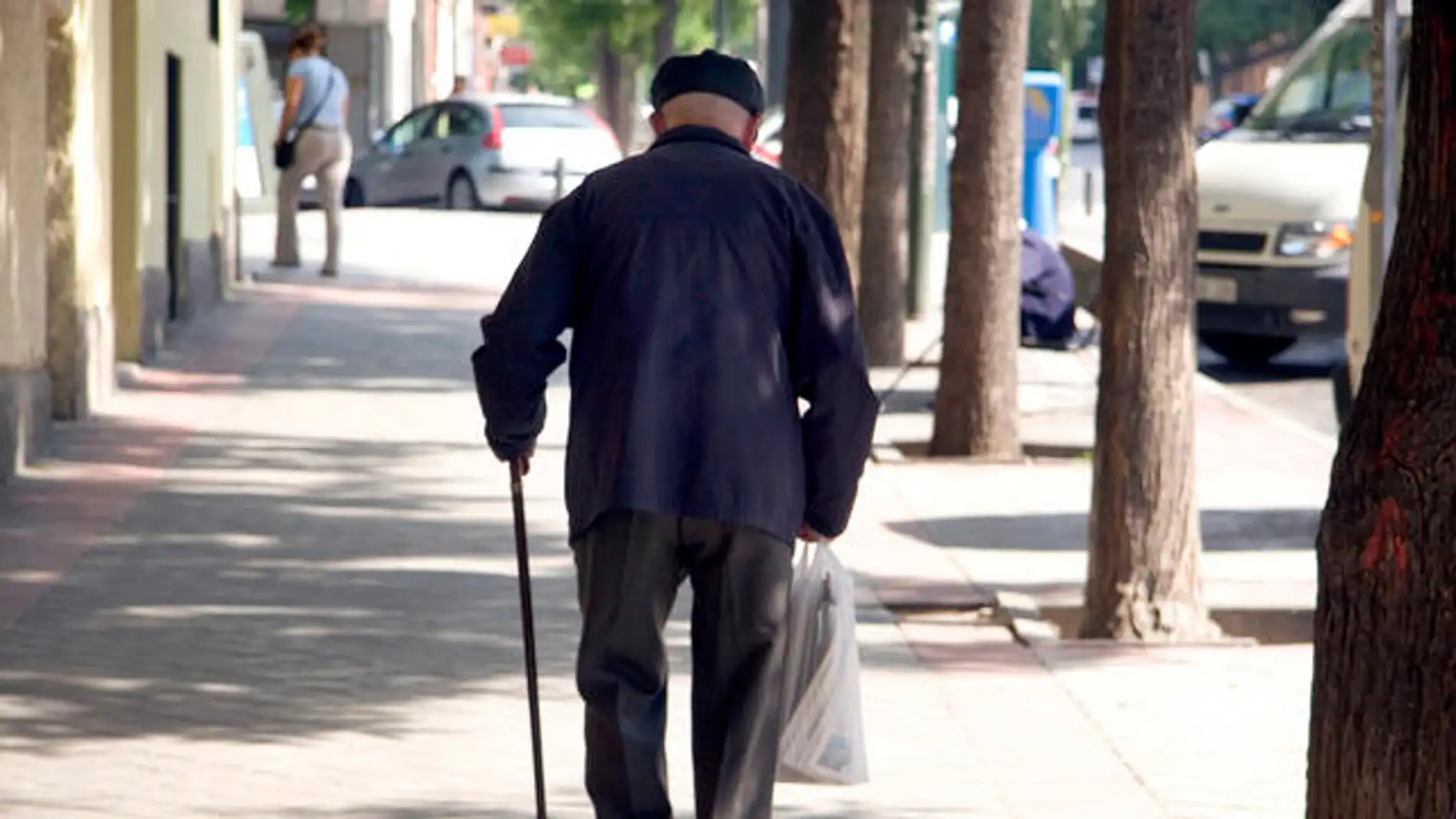Un jubilado camina en una calle.