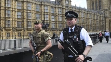 Un policía y un militar del Gobierno británico patrullando por la ciudad