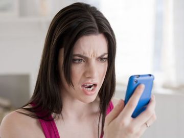 Mujer mirando el móvil enfadada