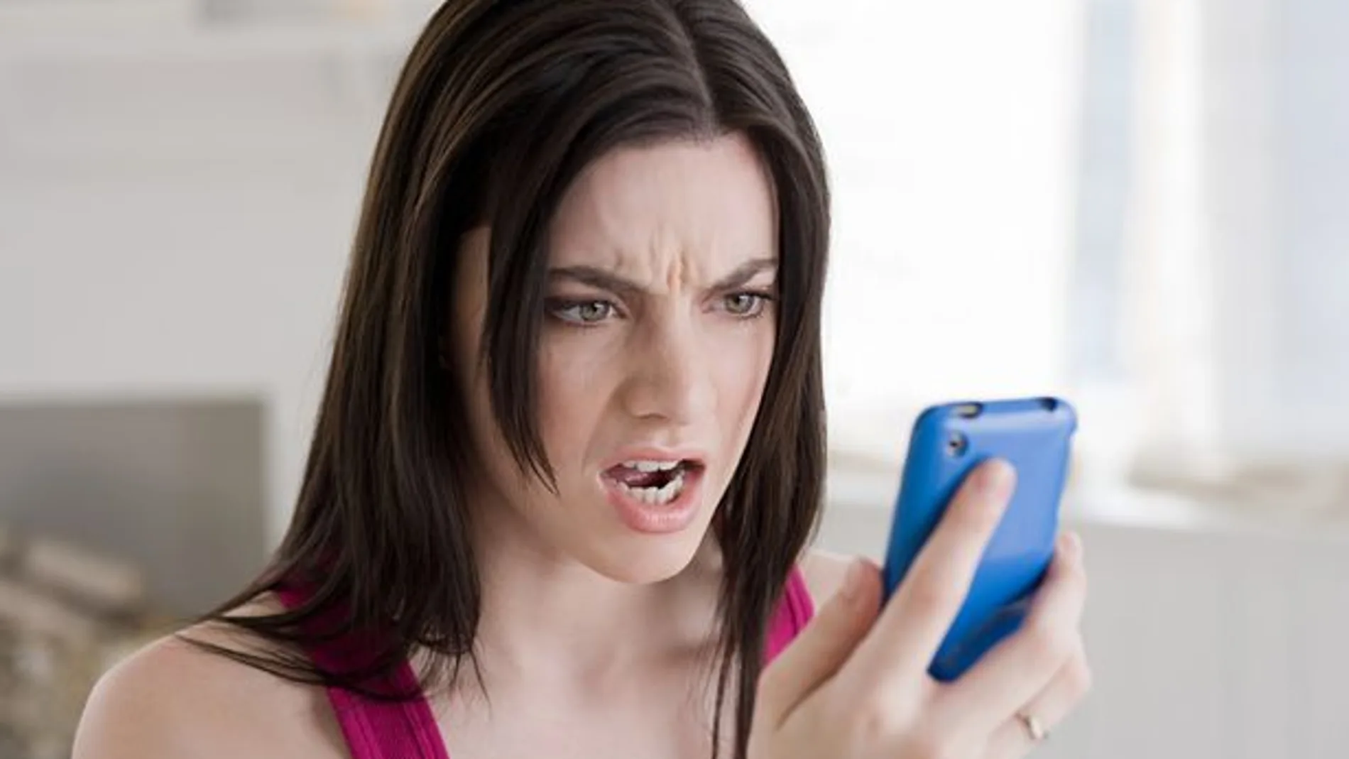 Mujer mirando el móvil enfadada