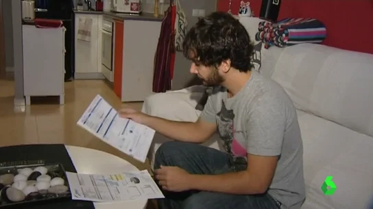 Un joven analiza al detalle sus facturas Un joven analiza al detalle sus facturas