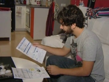 Un joven analiza al detalle sus facturas Un joven analiza al detalle sus facturas