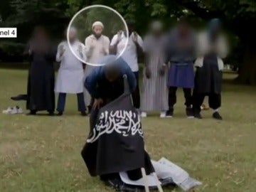 Terrorista mostrando una bandera de Daesh Terrorista mostrando una bandera de Daesh