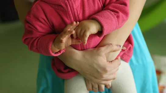 Una mujer sostiene a un bebé Una mujer sostiene a un bebé