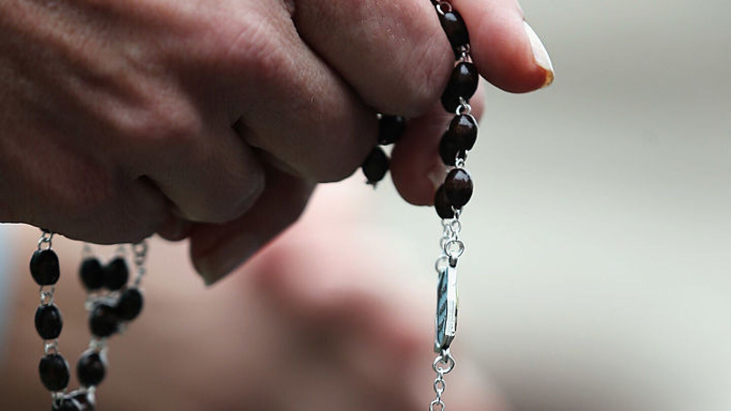 Una mujer con un rosario en la mano