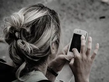 Una usuaria con su iPhone Una usuaria con su iPhone