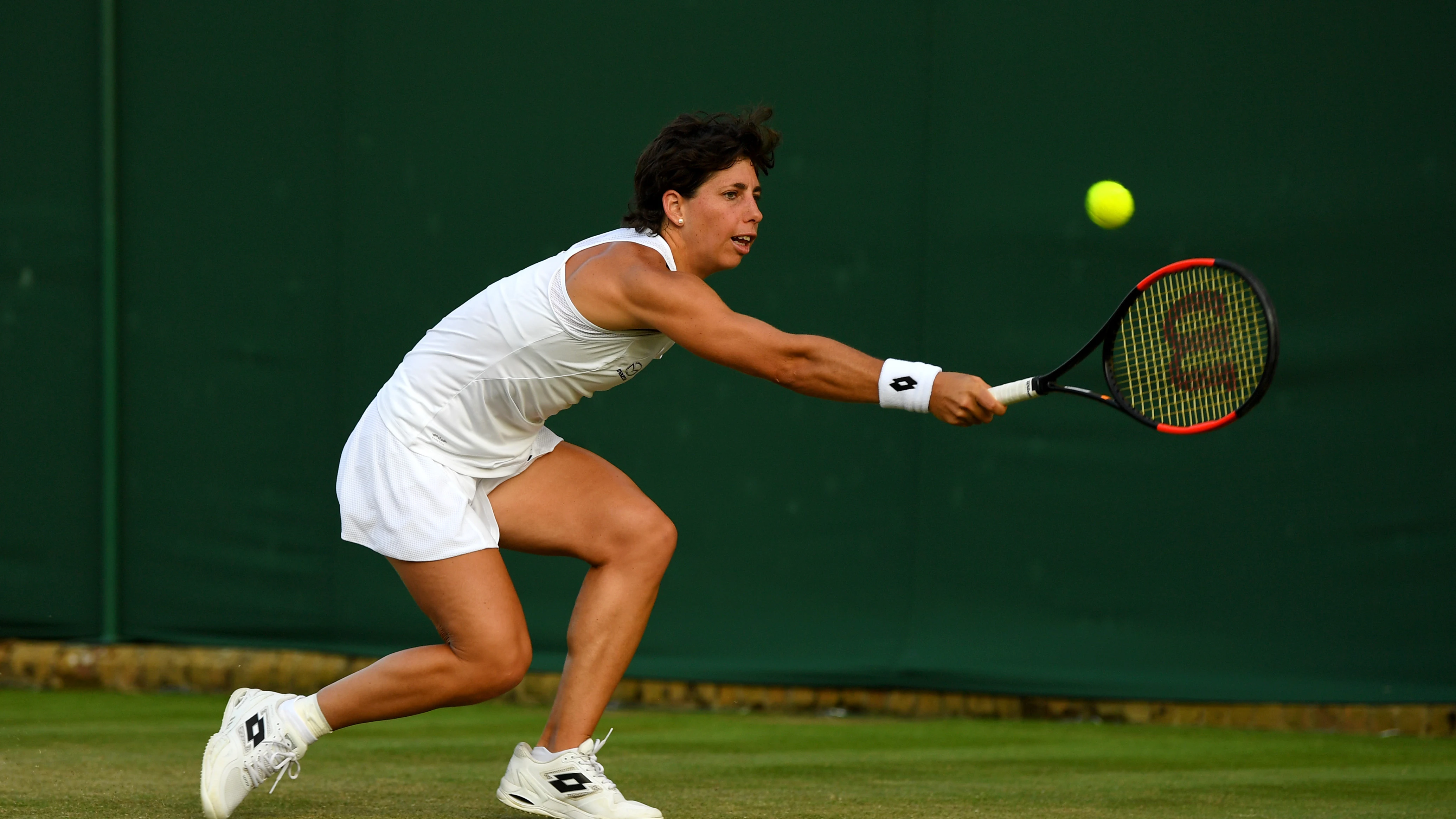 Carla Suárez trata de restar una pelota ante Shuai Peng