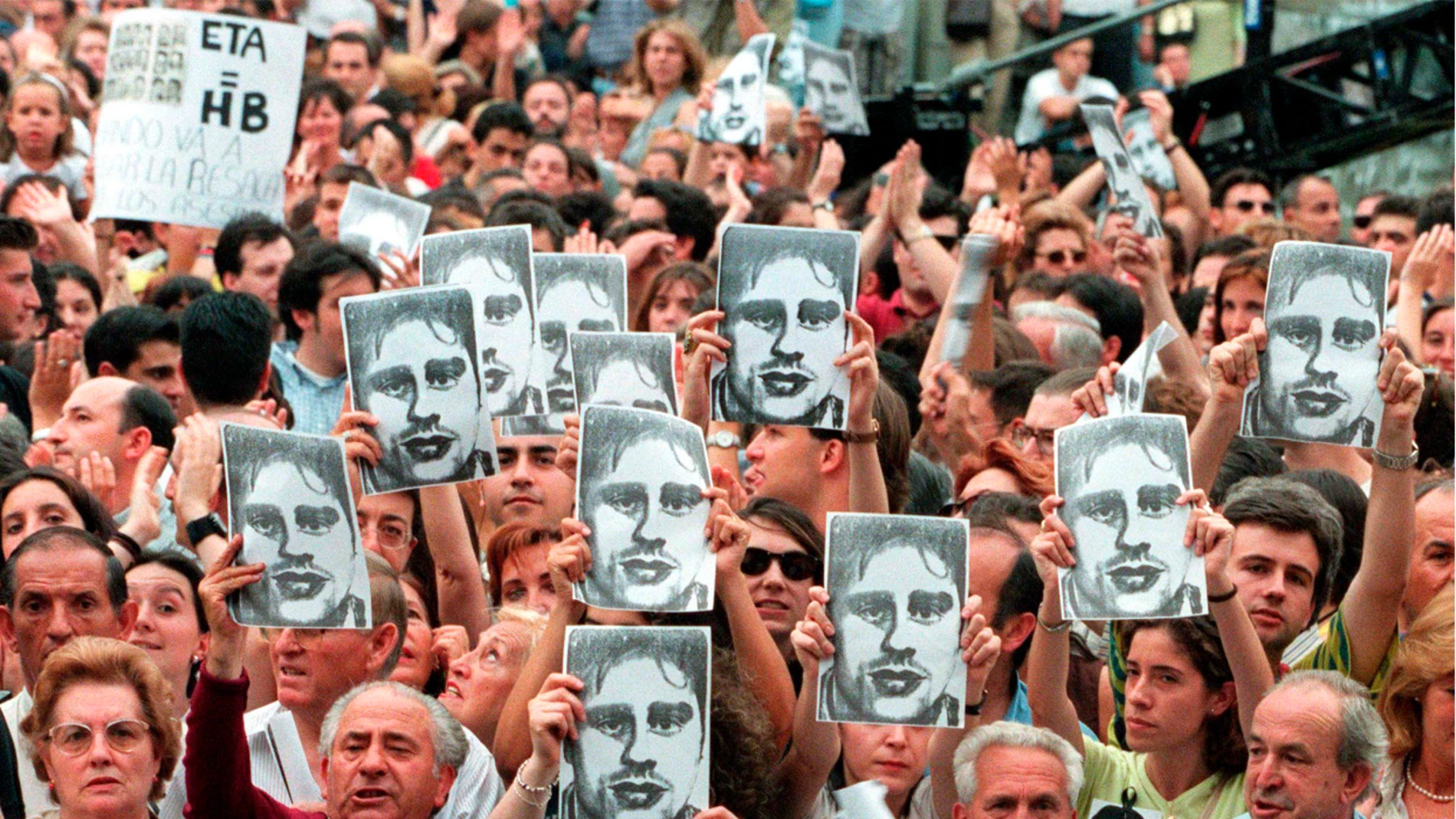 Manifestantes portan fotos de Miguel Ángel Blanco durante la manifestación en Madrid 