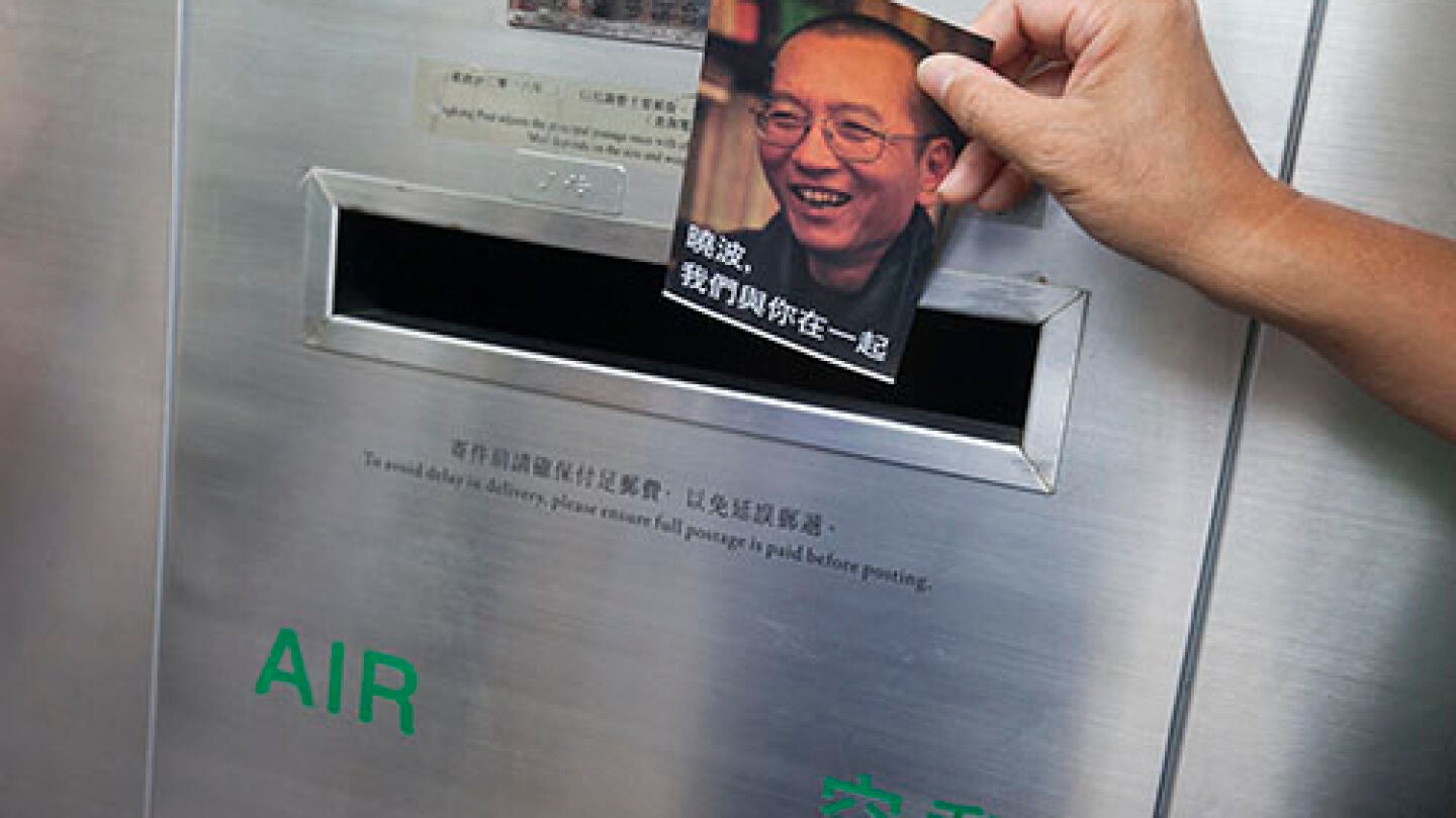 Un activista de la Alianza de Hong Kong de Apoyo a los Movimientos Democr&aacute;ticos Patri&oacute;ticos de China echa al buz&oacute;n una de las mil postales con mensajes de apoyo al disidente chino Liu Xiaobo