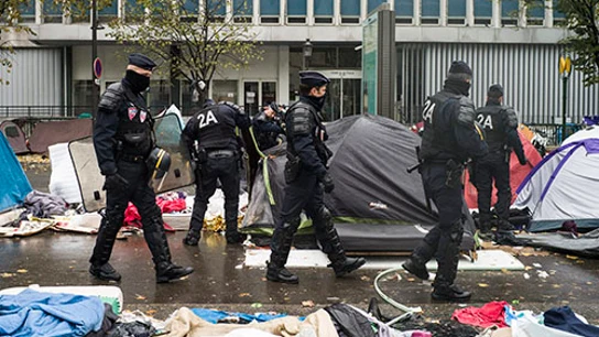 Agentes de policía galos inspeccionan las tiendas de campaña desalojo de un campamento en el distrito 19 de París, Francia Agentes de policía galos inspeccionan las tiendas de campaña desalojo de un campamento en el distrito 19 de París, Francia