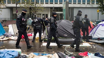 Agentes de policía galos inspeccionan las tiendas de campaña desalojo de un campamento en el distrito 19 de París, Francia