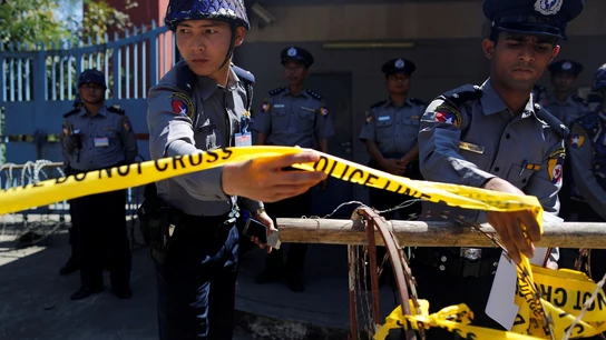 Policías de Tailandia poniendo un cordón policial Las policías guardan la guardia durante una protesta de los monjes y de los activistas budistas de Myanmar delante de la embajada tailandesa en Yangon