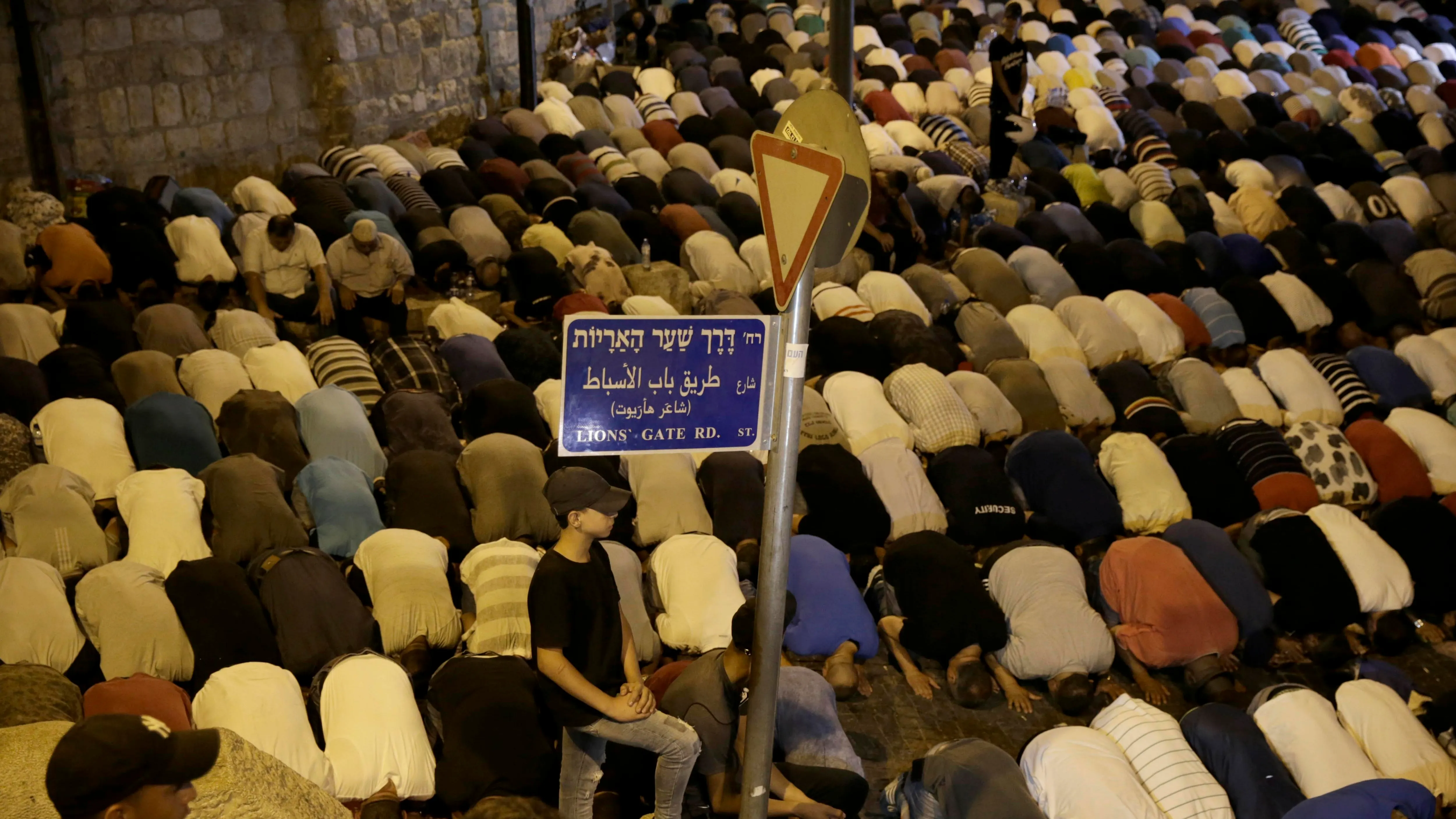 Ciudadanos palestinos rezan fuera de la Puerta de los Leones, la principal entrada a la mezquita de Al-Aqsa