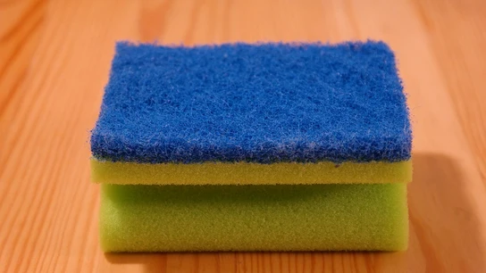 Imagen de un estropajo de cocina apoyado sobre una mesa Imagen de un estropajo de cocina apoyado sobre una mesa