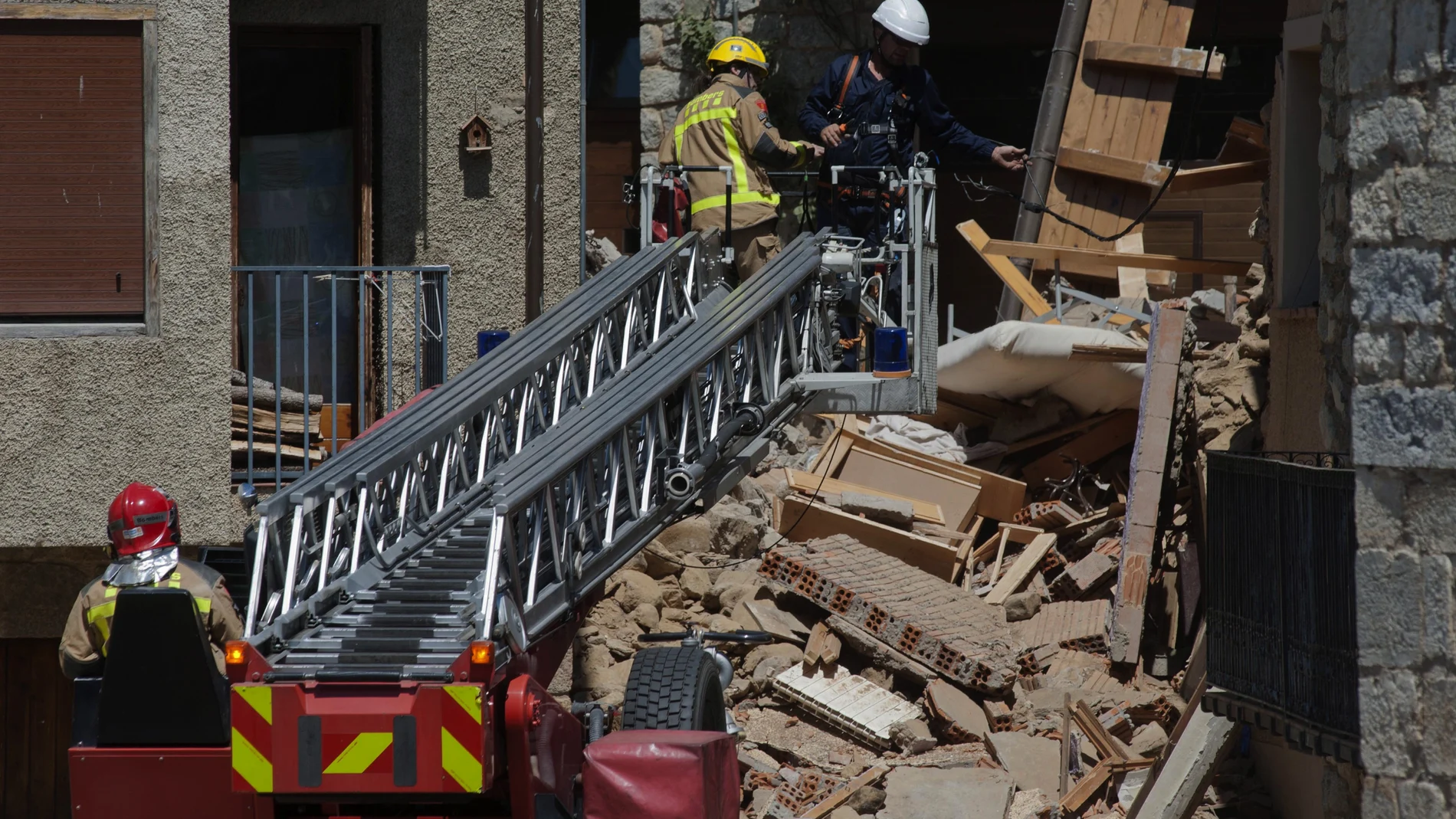 Miembros de los bomberos trabajando en las ruinas de una casa en Llanars (Girona) que se ha derrumbado provocando dos heridos