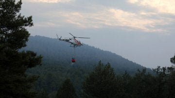 Un helicóptero trabaja en las labores de extinción del incendio forestal declarado en el municipio de Artés (Barcelona)