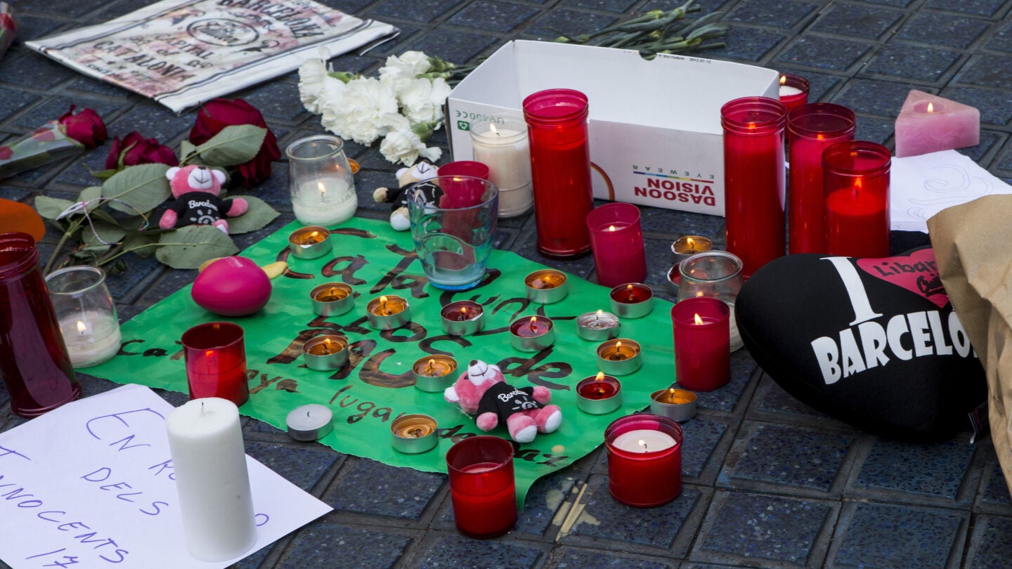 Varios transe&uacute;ntes depositan mensajes y velas en el mosaico de Mir&oacute; en las Ramblas