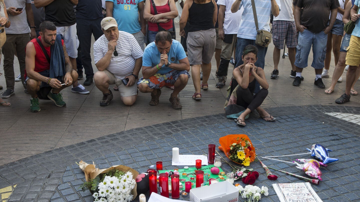 Varias personas se paran frente al mosaico de Mir&oacute; en las Ramblas de Barcelona