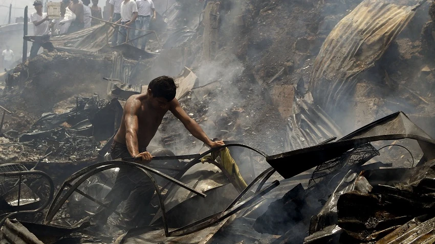 Un hombre busca sus pertenencias tras el incendio de Medellín