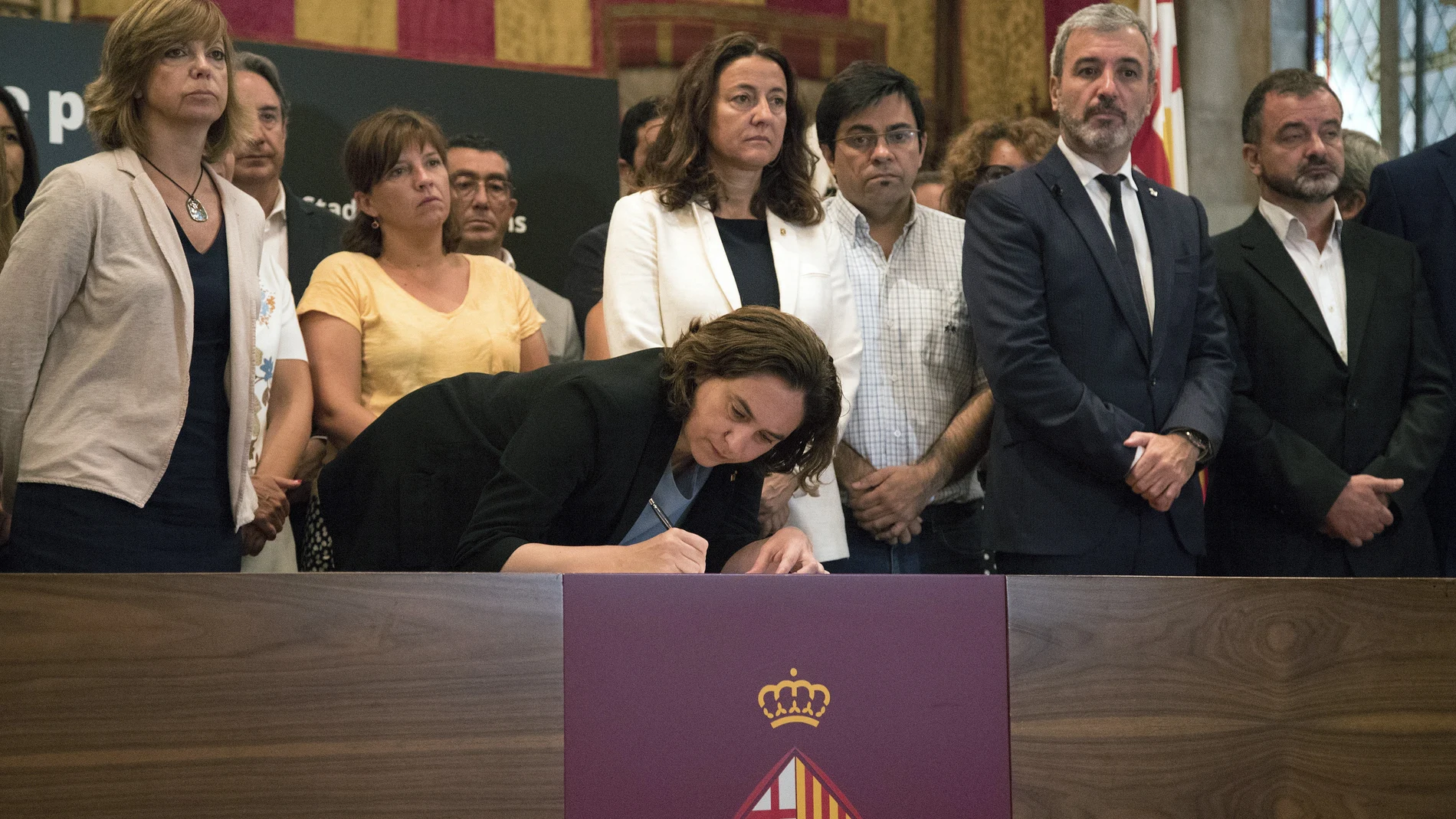 La alcaldesa de Barcelona, Ada Colau, acompañada de autoridades, firma en el libro de condolencias