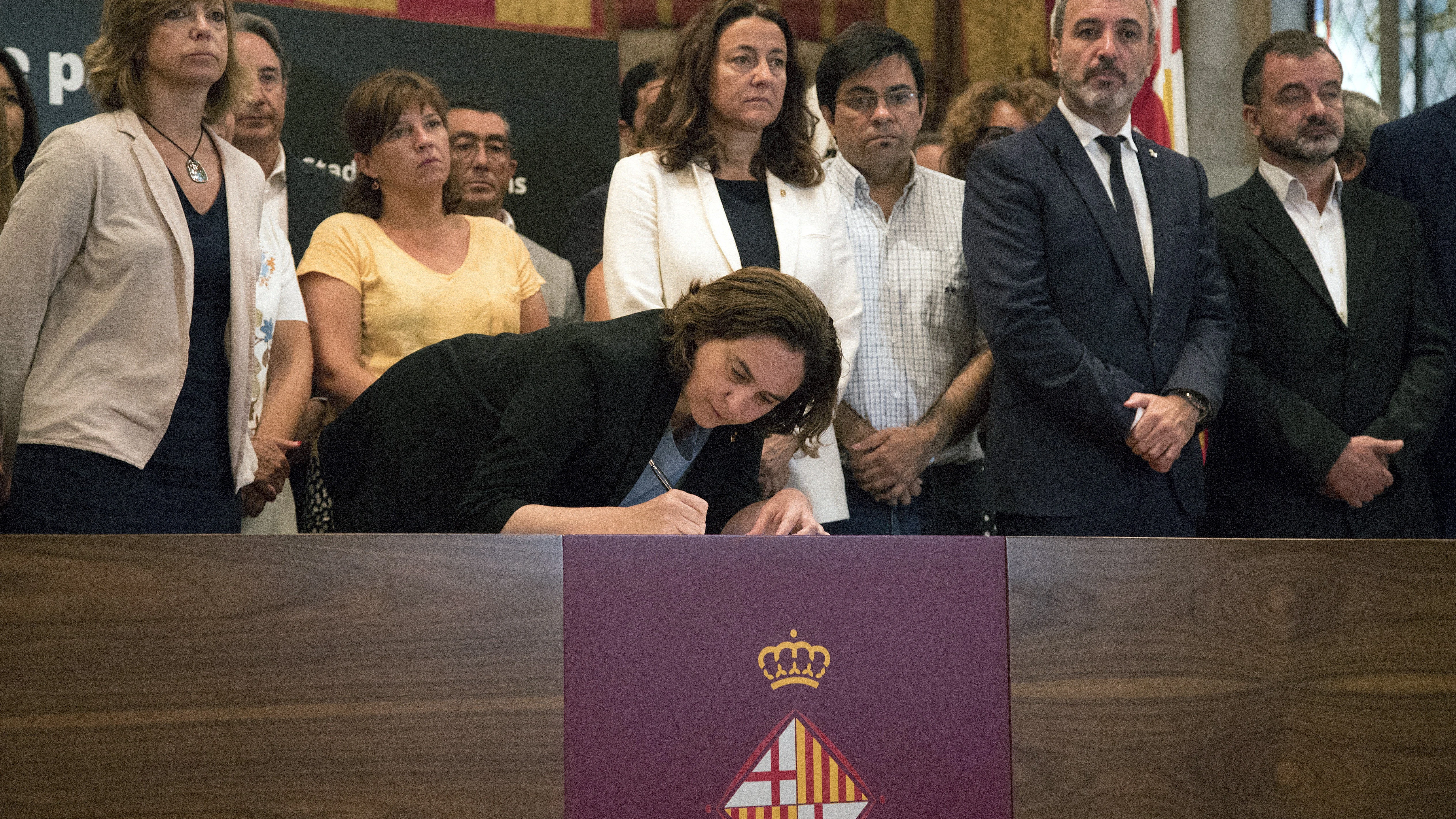 La alcaldesa de Barcelona, Ada Colau, acompañada de autoridades, firma en el libro de condolencias