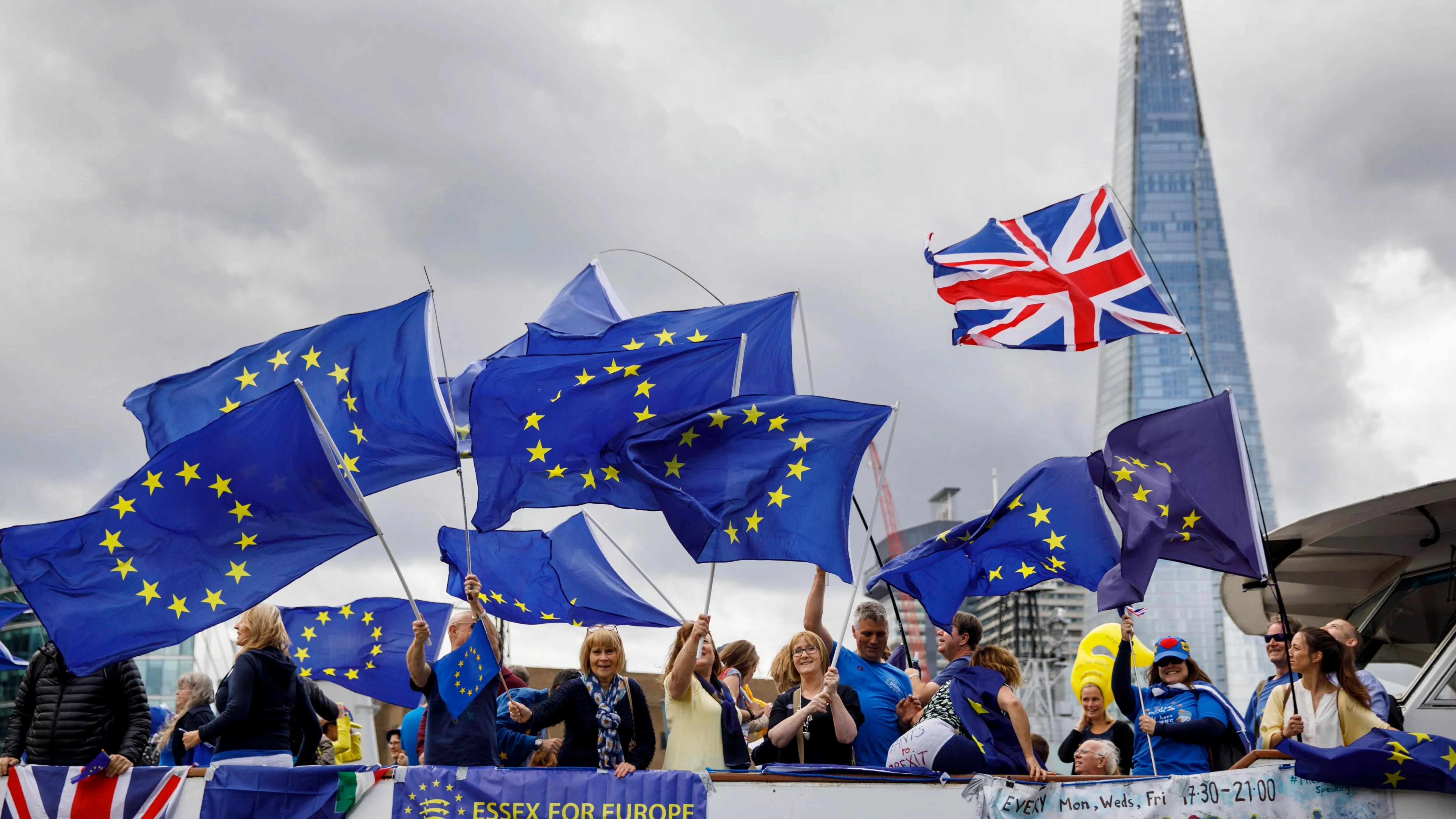 Varias personas con banderas de la Unión Europea protestan contra el brexit en un barco por el río Támesis, en Londres