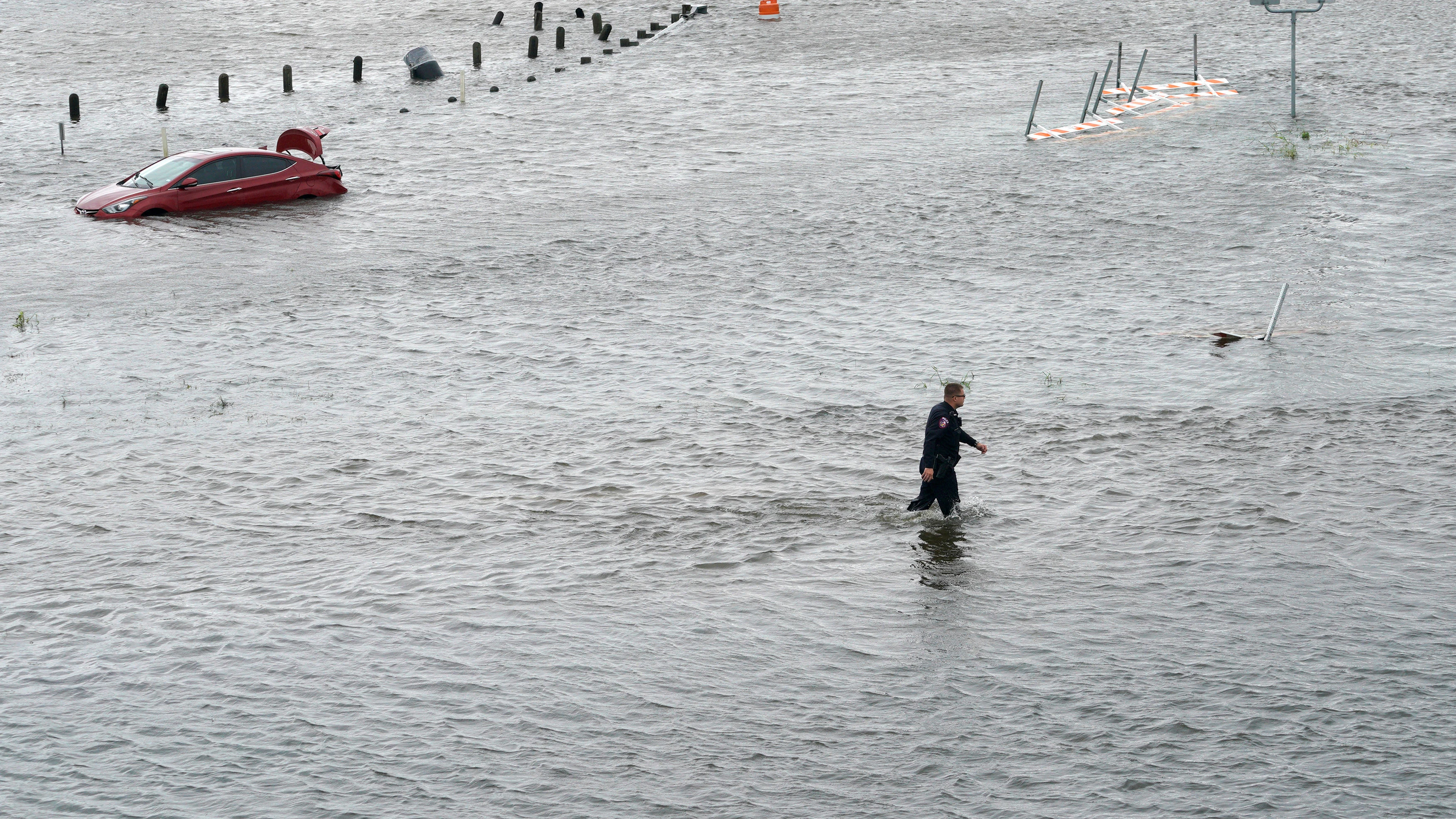 Un agente de policía atraviesa las inundaciones provocadas por la tormenta 'Harvey' en Texas