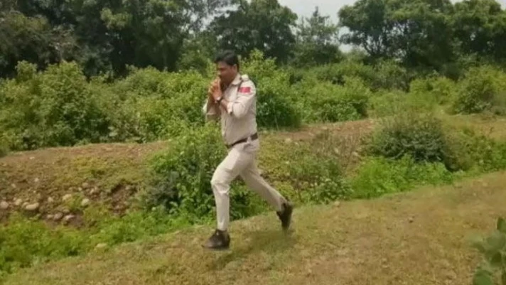 Policía corriendo con una bomba en sus propias manos