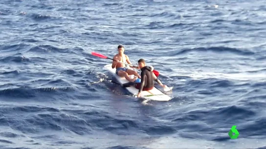 Migrantes sobre una tabla de surf Migrantes sobre una tabla de surf