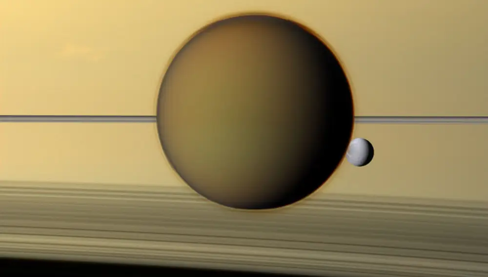 Saturno tiene nada y nada menos que 62 lunas confirmadas. Las de la fotografía son dos de ellas, Titán y Dione, posando con los anillos de su inseparable compañero de fondo. La mayor parte de Dione está cubierta de hielo, pero Cassini ha detectado pistas que sugieren la presencia de un océano de agua líquida.