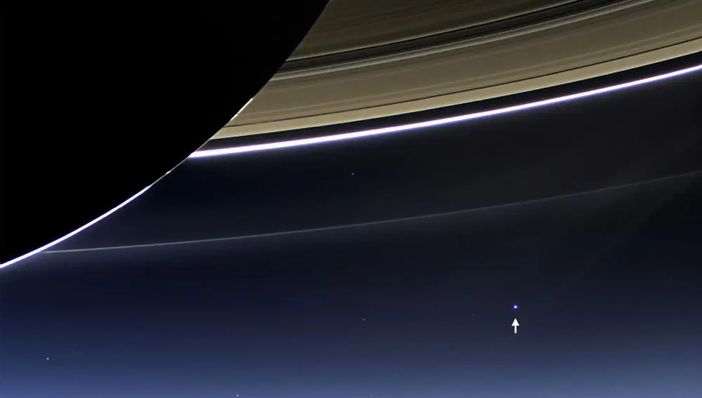 En esta imagen no hay que fijarse en la enorme panza de Saturno ni en sus colosales anillos, sino en el diminuto punto que puede verse en el horizonte. Es la Tierra, vista desde 1.440 millones de kilómetros.