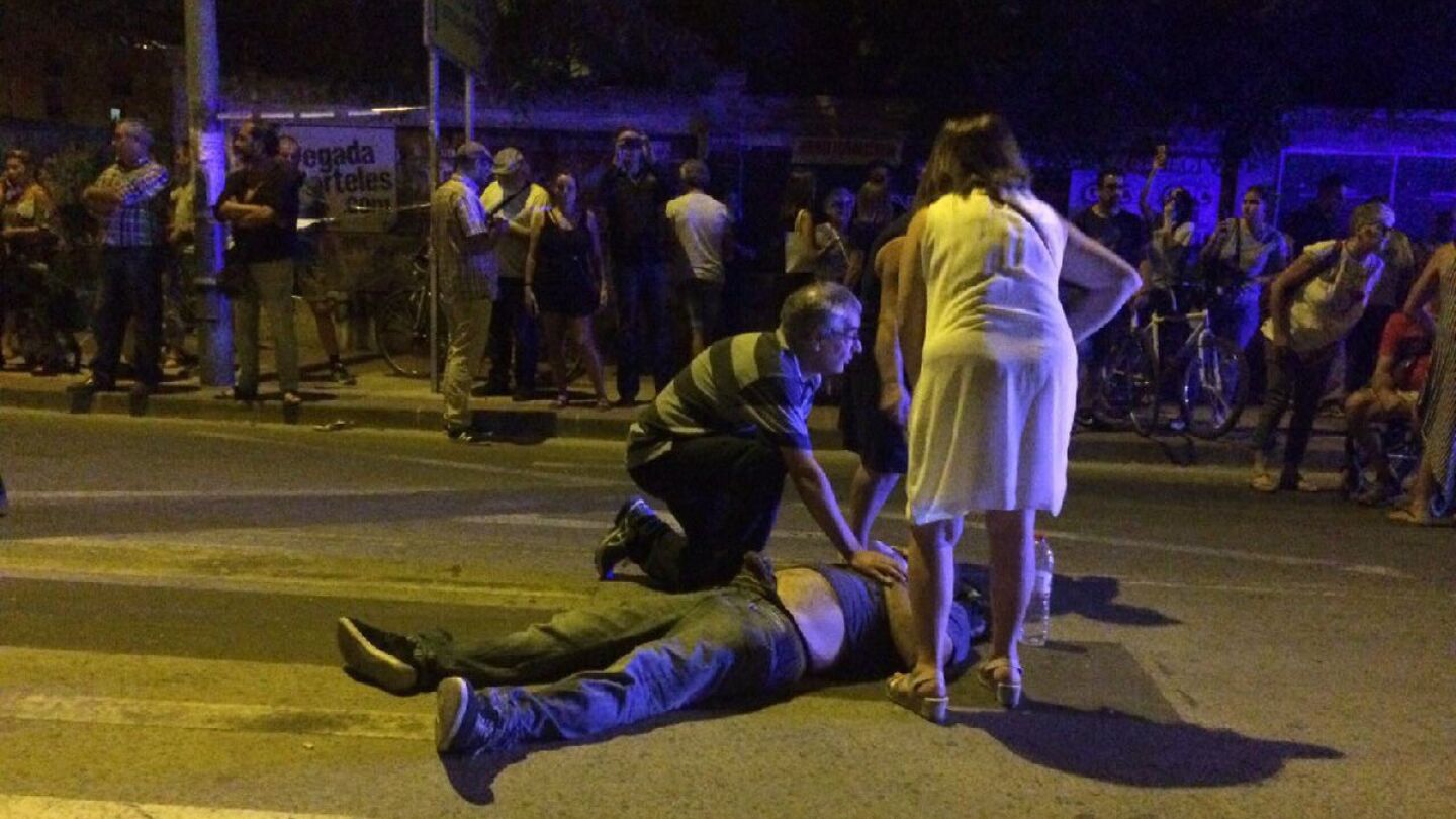 Un hombre atiende a uno de los manifestantes heridos
