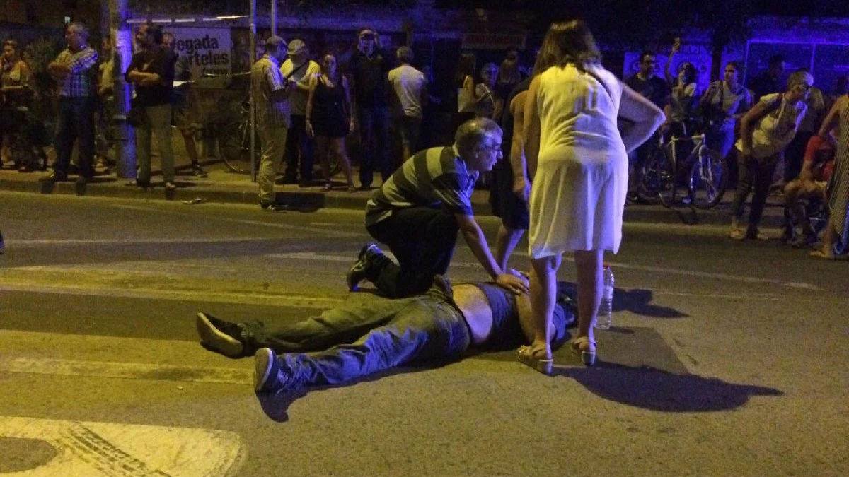 Un hombre atiende a uno de los manifestantes heridos