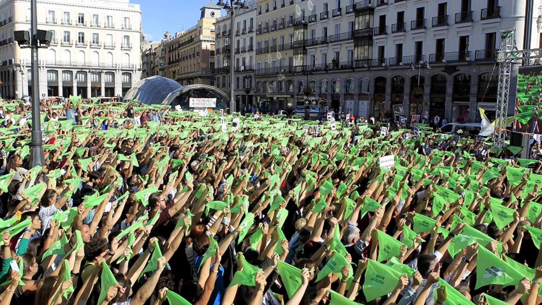 Miles de personas convocadas por el Partido Animalista Pacma, en la Puerta del Sol de Madrid, portan pañuelos verdes para simular un "chupinazo animalista" en una manifestación contra la tauromaquia 