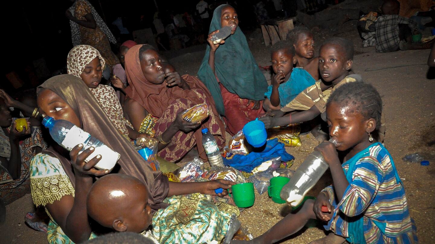 Una familia nigeriana come su raci&oacute;n de alimentos en un campamento de desplazados internos en Maiduguri (Nigeria)