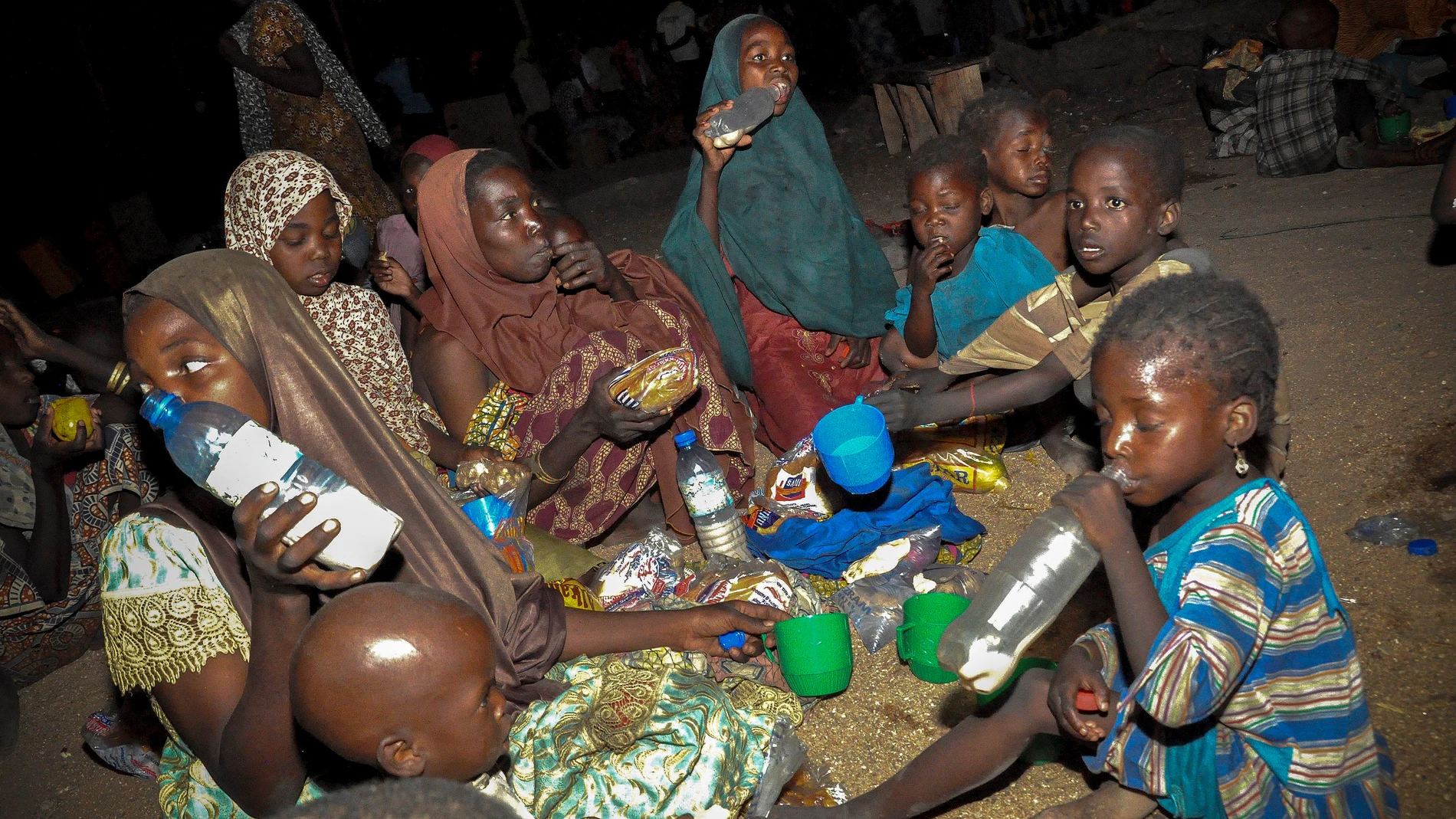 Una familia nigeriana come su ración de alimentos en un campamento de desplazados internos en Maiduguri (Nigeria)